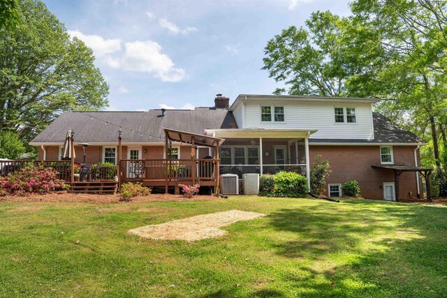 229 Cart Dr, Spartanburg, SC 29307 - rear view of property featuring a sunroom, a chimney, brick siding, and a yard