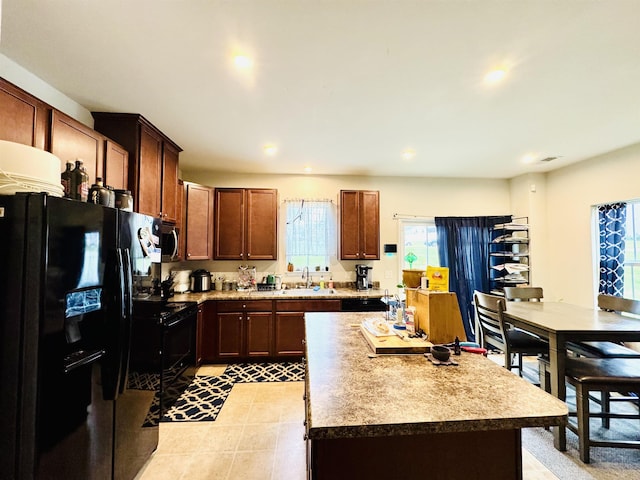 411 Triple Crown Way, Spartanburg, SC 29301 - kitchen with black refrigerator with ice dispenser, healthy amount of natural light, a kitchen island, recessed lighting, and light tile patterned floors