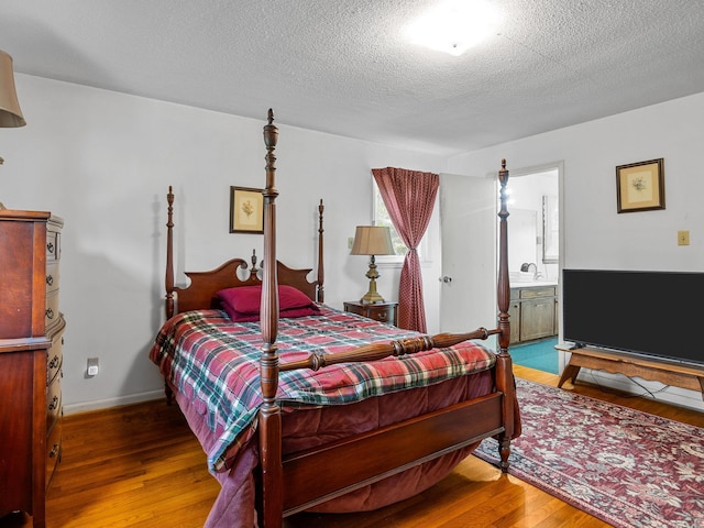 1310 Mount Zion Rd, Spartanburg, SC 29303 - bedroom featuring wood finished floors, a textured ceiling, and ensuite bathroom