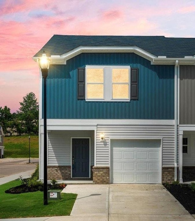 126 Arrow Ct, Greer, SC 29651 - view of front facade with concrete driveway, brick siding, a garage, and board and batten siding