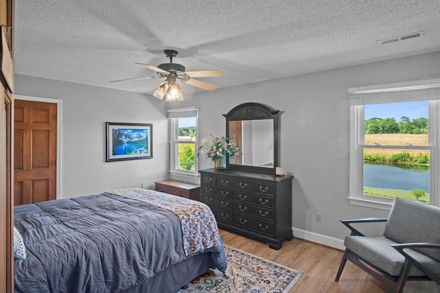 270 Watkins Rd, Campobello, SC 29322 - bedroom featuring multiple windows, light wood finished floors, a textured ceiling, and a ceiling fan