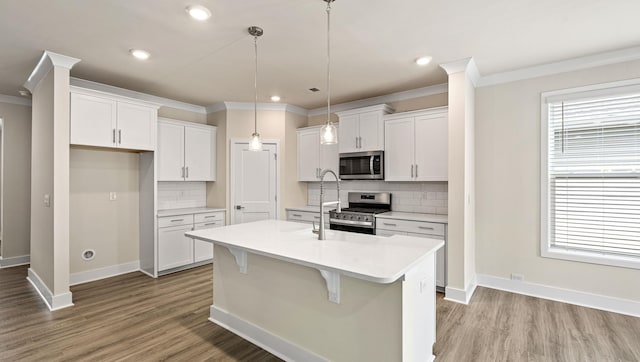 310 Fiery Rd, Mauldin, SC 29607 - kitchen with stainless steel appliances, crown molding, backsplash, a kitchen island with sink, and light countertops