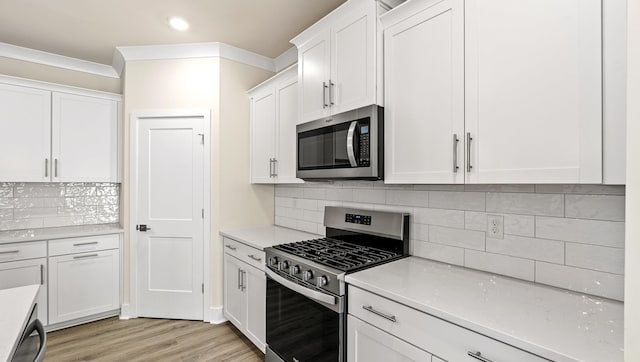 310 Fiery Rd, Mauldin, SC 29607 - kitchen with stainless steel appliances, white cabinetry, light countertops, light wood-style flooring, and ornamental molding