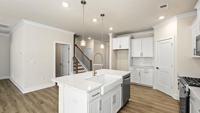 310 Fiery Rd, Mauldin, SC 29607 - kitchen with black gas range oven, crown molding, decorative backsplash, recessed lighting, and white cabinetry