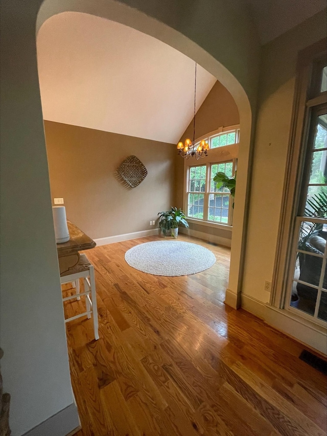 204 Tuscan Ridge Trl, Inman, SC 29349 - dining space with arched walkways, vaulted ceiling, wood finished floors, and a chandelier