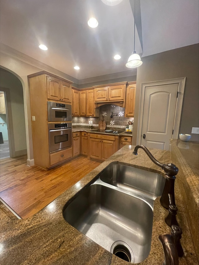 204 Tuscan Ridge Trl, Inman, SC 29349 - kitchen featuring black electric cooktop, arched walkways, decorative backsplash, ornamental molding, and decorative light fixtures