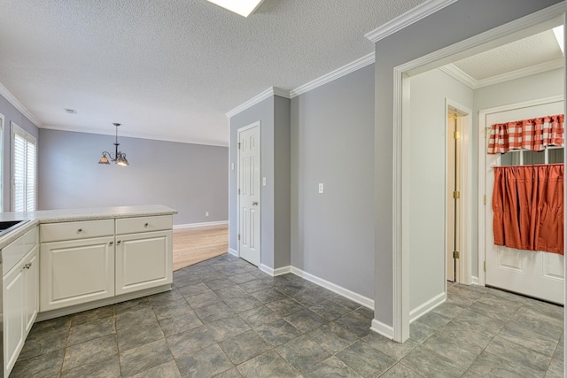 15 Arbours W Ln, Moore, SC 29369 - kitchen featuring a chandelier, stone finish floors, white cabinets, ornamental molding, and decorative light fixtures