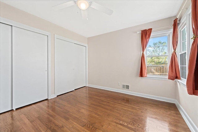 222 Woodview Ave, Spartanburg, SC 29306 - unfurnished bedroom featuring wood finished floors, multiple closets, and ceiling fan
