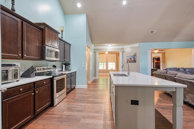 202 Buxton Ct, Easley, SC 29642 - kitchen featuring stainless steel appliances, open floor plan, dark brown cabinetry, and an island with sink