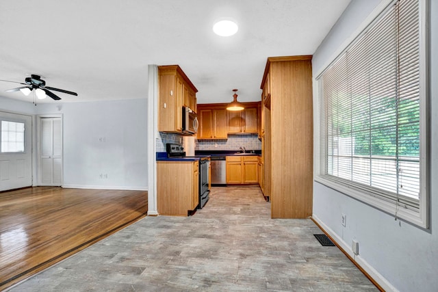211 Skyline Rd, Greer, SC 29651 - kitchen with appliances with stainless steel finishes, decorative backsplash, light wood-style floors, and a ceiling fan