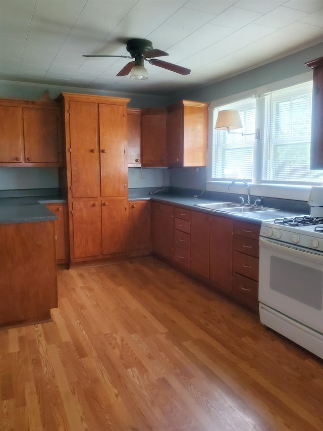190 Beaverdam Church Rd, Enoree, SC 29335 - kitchen with white range with gas cooktop, light wood-style flooring, brown cabinets, and ceiling fan