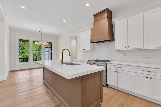 3963 Pennington Rd, Greer, SC 29651 - kitchen featuring high end stainless steel range, custom range hood, light wood finished floors, light countertops, and white cabinets