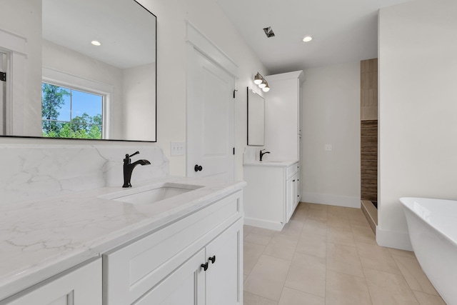 3963 Pennington Rd, Greer, SC 29651 - full bathroom with two vanities, a freestanding bath, recessed lighting, tasteful backsplash, and tile patterned flooring