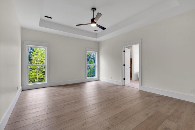 3963 Pennington Rd, Greer, SC 29651 - unfurnished room featuring a tray ceiling, plenty of natural light, a ceiling fan, and light wood finished floors