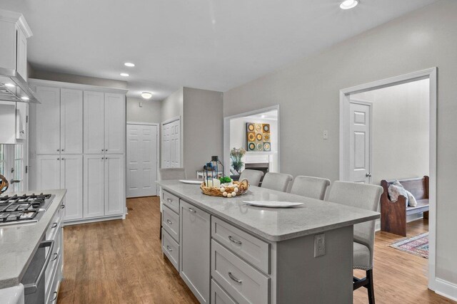 155 Lake Park Dr, Spartanburg, SC 29301 - kitchen with a kitchen bar, a kitchen island, stainless steel gas cooktop, light wood-style flooring, and recessed lighting