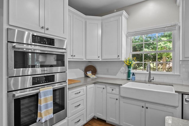 155 Lake Park Dr, Spartanburg, SC 29301 - kitchen featuring stainless steel double oven, backsplash, and white cabinets