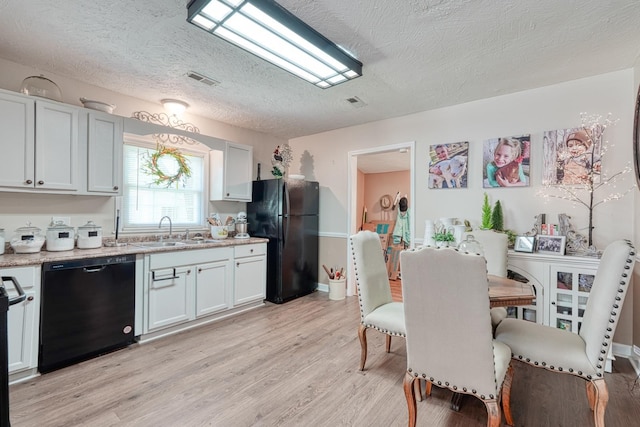 1762 New Cut Rd, Spartanburg, SC 29303 - kitchen with black appliances, light wood-style floors, a textured ceiling, light stone countertops, and white cabinetry