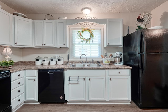 1762 New Cut Rd, Spartanburg, SC 29303 - kitchen with black appliances, white cabinetry, light wood-type flooring, a textured ceiling, and light countertops