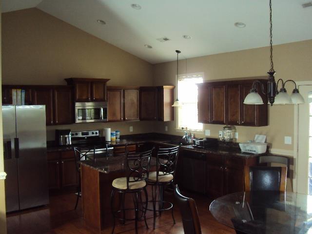 108 Dewfield Ln, Boiling Springs, SC 29316 - kitchen featuring stainless steel appliances, lofted ceiling, dark countertops, a chandelier, and a center island
