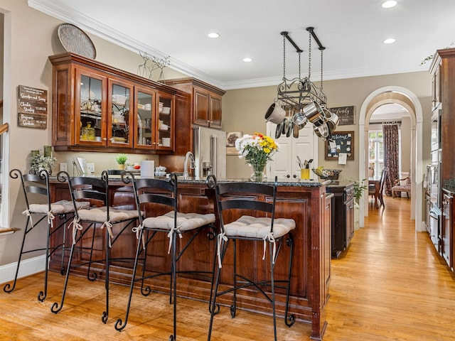 458 Carolina Club Dr, Spartanburg, SC 29306 - bar area with stainless steel appliances, light wood-style flooring, arched walkways, ornamental molding, and recessed lighting