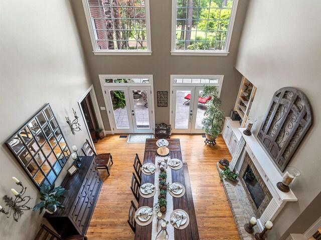 458 Carolina Club Dr, Spartanburg, SC 29306 - living room with a high ceiling, french doors, plenty of natural light, a fireplace, and light wood-type flooring
