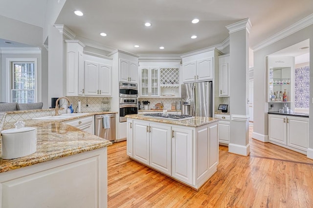 340 Hidden Creek Cir, Spartanburg, SC 29306 - kitchen featuring appliances with stainless steel finishes, ornamental molding, light wood-style flooring, light stone counters, and backsplash