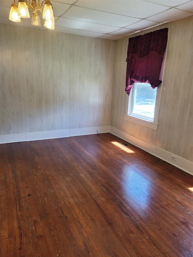 225 Limestone St, Pacolet, SC 29372 - empty room with wood-type flooring, a chandelier, wooden walls, and a paneled ceiling