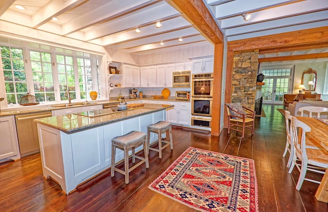 735 Jackson Grove Rd, Landrum, SC 29356 - kitchen featuring appliances with stainless steel finishes, beam ceiling, white cabinets, dark wood-type flooring, and a breakfast bar area