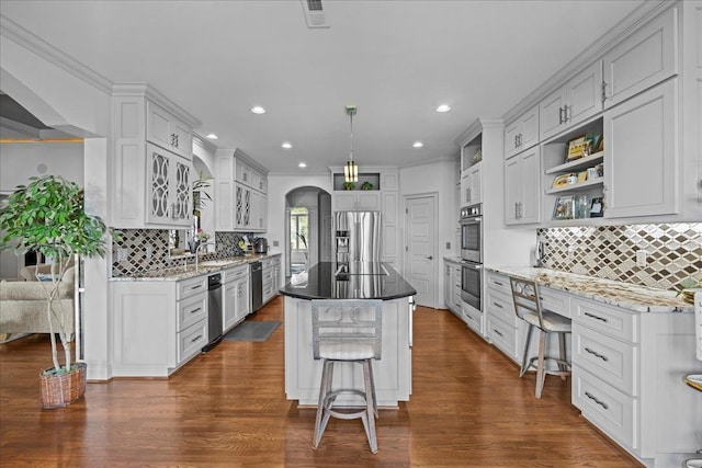 135 Neal Pointe Dr, Chesnee, SC 29323 - kitchen featuring appliances with stainless steel finishes, arched walkways, decorative backsplash, dark wood-type flooring, and recessed lighting