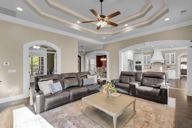 115 Gleneagles Rd, Campobello, SC 29322 - living room with arched walkways, ceiling fan, a raised ceiling, crown molding, and dark wood-style flooring
