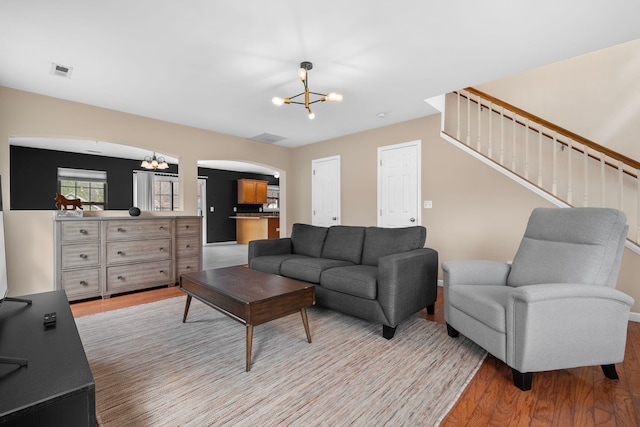 100 Maximus Dr, Greer, SC 29651 - living room with light wood-style floors, a chandelier, stairs, and arched walkways