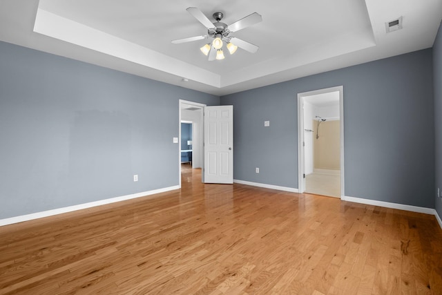 100 Maximus Dr, Greer, SC 29651 - unfurnished bedroom featuring a raised ceiling, light wood finished floors, and ceiling fan