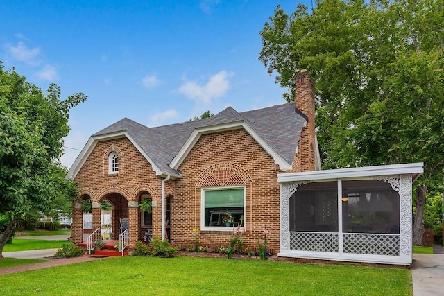 203 E S St, Union, SC 29379 - view of front of home featuring brick siding, a sunroom, a front yard, a chimney, and roof with shingles