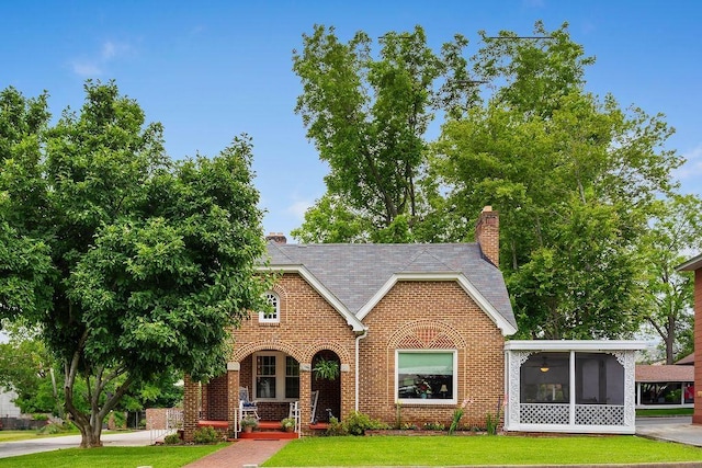 203 E S St, Union, SC 29379 - tudor house with brick siding, a front yard, a chimney, and a porch