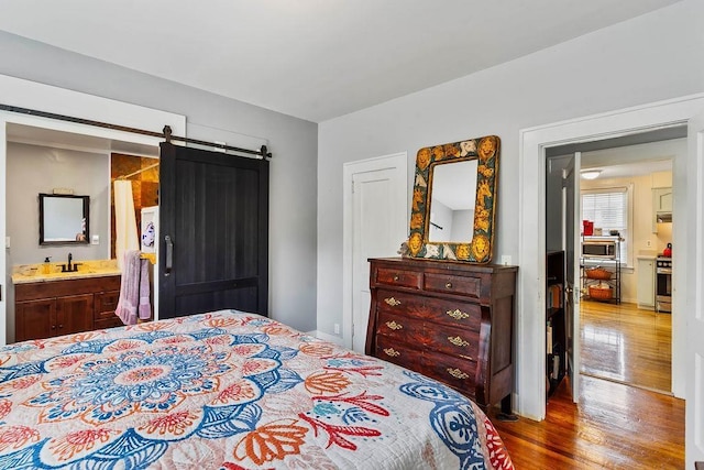203 E S St, Union, SC 29379 - bedroom featuring wood finished floors, ensuite bath, and a barn door