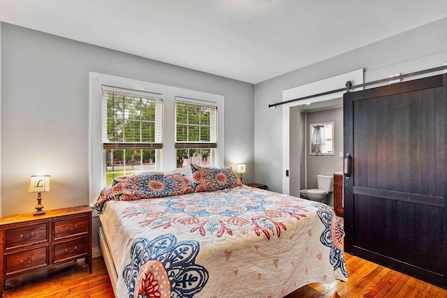 203 E S St, Union, SC 29379 - bedroom featuring wood finished floors, a barn door, and ensuite bath