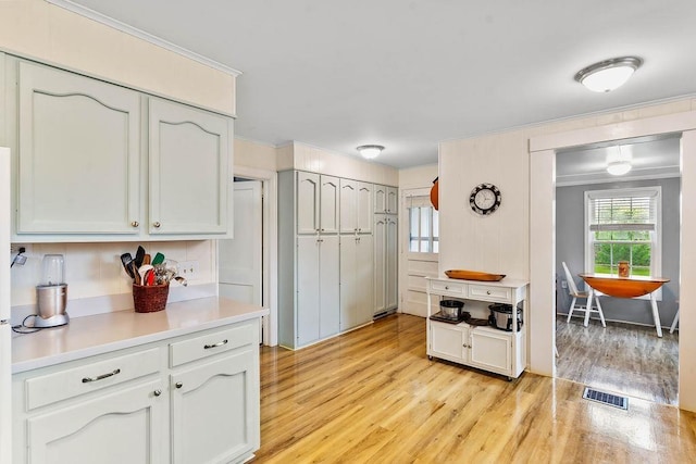 203 E S St, Union, SC 29379 - kitchen featuring light wood finished floors, light countertops, crown molding, and white cabinets