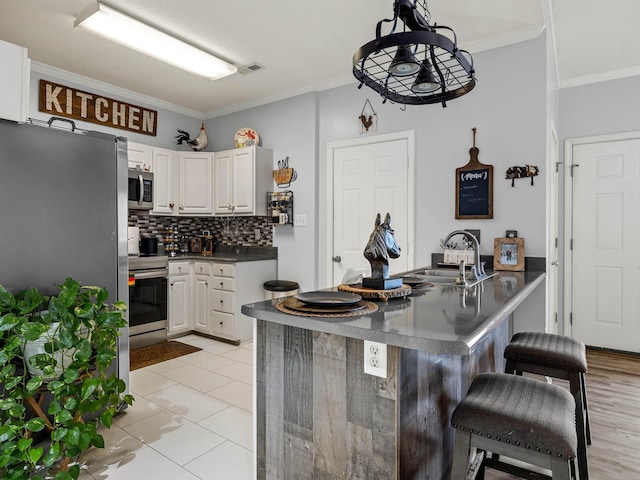 110 Hidden Ridge Dr, Spartanburg, SC 29301 - kitchen with appliances with stainless steel finishes, a kitchen breakfast bar, dark countertops, tasteful backsplash, and crown molding