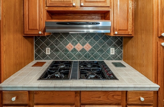 2250 Hickory Dr, Spartanburg, SC 29302 - kitchen with black gas stovetop, under cabinet range hood, decorative backsplash, and tile counters