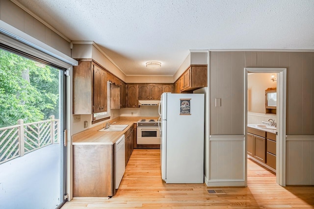 2250 Hickory Dr, Spartanburg, SC 29302 - kitchen featuring white appliances, light countertops, light wood-type flooring, a textured ceiling, and extractor fan