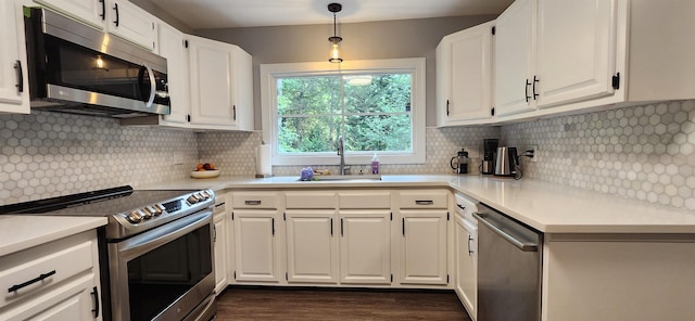 192 Wellesley Dr, Spartanburg, SC 29307 - kitchen featuring appliances with stainless steel finishes, dark wood-style floors, light countertops, white cabinets, and pendant lighting