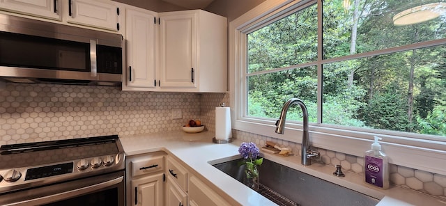 192 Wellesley Dr, Spartanburg, SC 29307 - kitchen featuring appliances with stainless steel finishes, light countertops, tasteful backsplash, and white cabinetry
