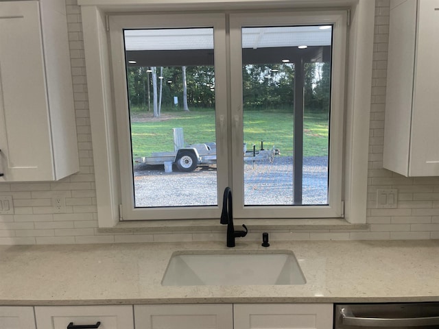 115 Hickory Hollow Rd, Inman, SC 29349 - kitchen view of tasteful backsplash, white cabinets, stainless steel dishwasher, and light stone countertops
