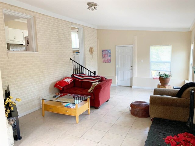 107 S Poplar Ave, Landrum, SC 29356 - living area featuring light tile patterned flooring, brick wall, and ornamental molding