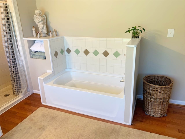 107 S Poplar Ave, Landrum, SC 29356 - bathroom featuring wood finished floors, a stall shower, and a bath