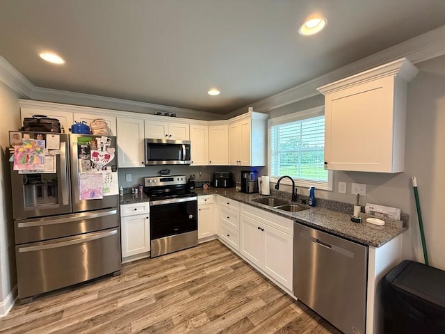 115 Rolling Mill Rd, Gaffney, SC 29340 - kitchen featuring appliances with stainless steel finishes, crown molding, light wood-type flooring, white cabinets, and dark stone counters