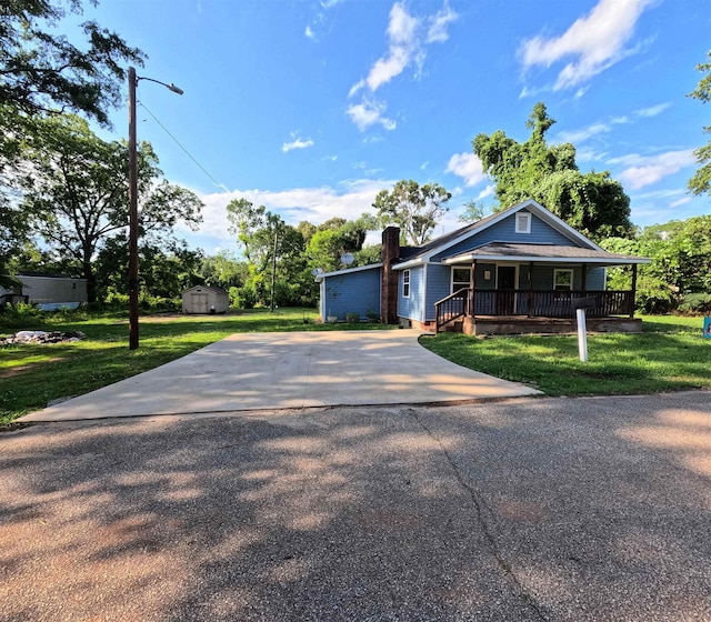 105 Anderson St, Spartanburg, SC 29301 - view of front facade with covered porch, a storage unit, a front lawn, and driveway