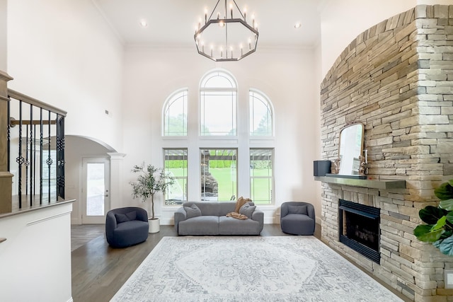 740 N Alamosa Dr, Boiling Springs, SC 29316 - living room featuring a stone fireplace, arched walkways, wood finished floors, a high ceiling, and a chandelier