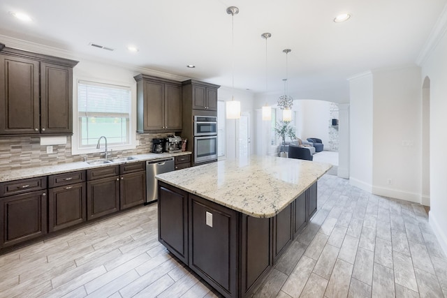 740 N Alamosa Dr, Boiling Springs, SC 29316 - kitchen featuring appliances with stainless steel finishes, arched walkways, tasteful backsplash, dark brown cabinetry, and crown molding