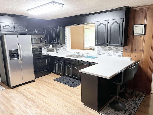355 Blue Ridge Rd, Campobello, SC 29322 - kitchen featuring black appliances, a textured ceiling, a peninsula, decorative backsplash, and light countertops